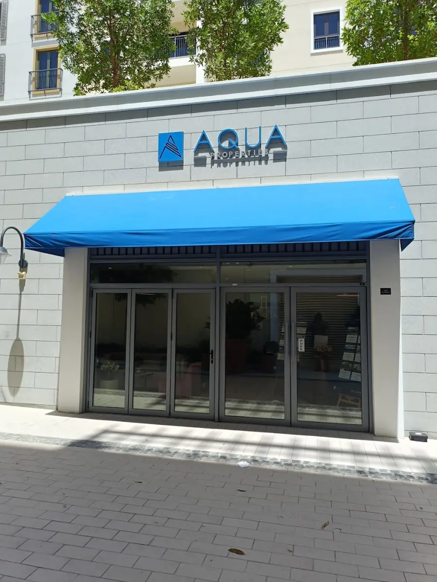 AQUA Properties storefront with its blue awning at Port de La Mer